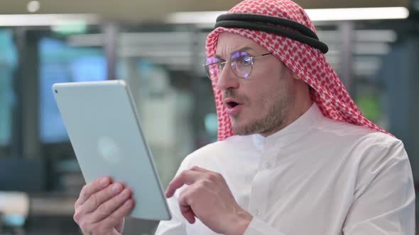 Middle Aged Arab Man Reactig to Loss on Tablet