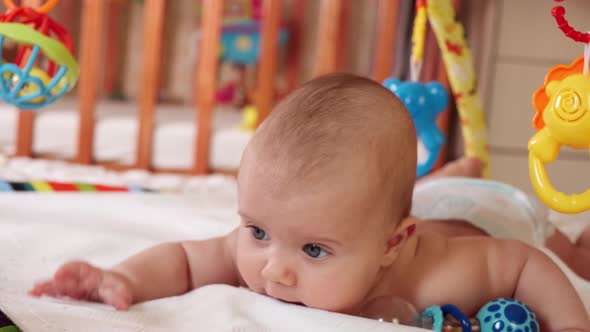 A Small Child Crawls on a Mat