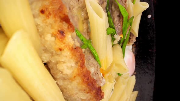 Tasty Cutlet Pieces Lie in Pan Among Pasta Eggs and Onion