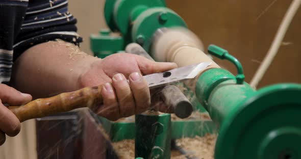 Side view of carpenter turning wood on a lathe