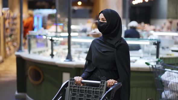 Woman in Hijab and Protective Mask Doing Grocery Pushing Shopping Cart