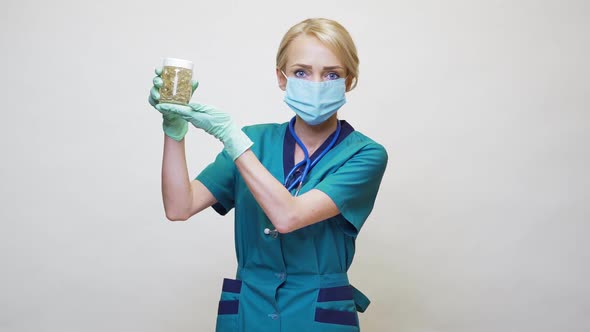 Medical Doctor Nurse Woman Wearing Protective Mask and Rubber or Latex Gloves - Holding Pills