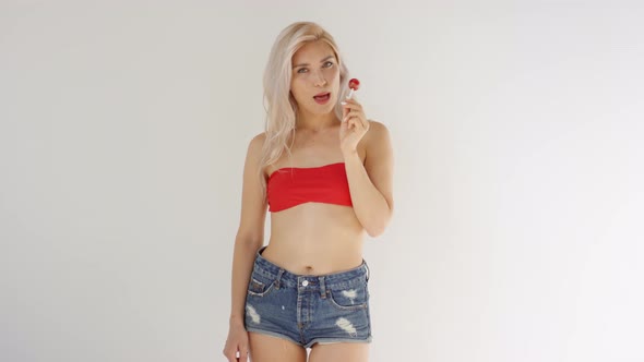 Young Caucasian Blonde Licking Lollipop in Studio