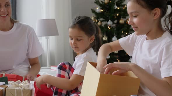 Happy Family with Christmas Gifts in Bed at Home