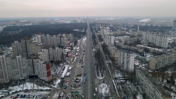 Drone View of Car Traffic on Road Passing Through Big European City at Winter Cloudy Evening