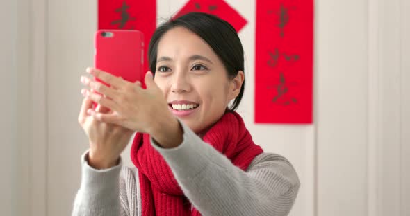 Chinese woman taking selfie and holding with red packet in lunar new year holiday