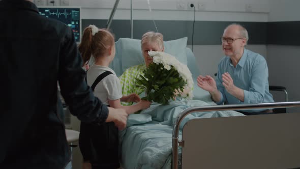 Old Patient Receiving Visit From Child and Mother in Hospital Ward