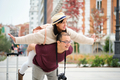 Happy multi-ethnic traveler couple piggyback with spread arms like plane wings. - PhotoDune Item for Sale