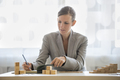 Woman writing on notepad beside wooden blocks - PhotoDune Item for Sale