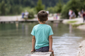 Young boy sitting by lake - PhotoDune Item for Sale