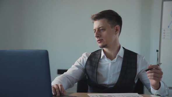 American Man Lawyer Working with Laptop and Legal Document at Table in Office.