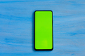 Phone smartphone, green screen on Blue wood background top view - PhotoDune Item for Sale