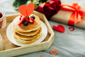 Valentine's day breakfast concept. Pancakes with berries, roses flowers, cup of tea, gift box. - PhotoDune Item for Sale