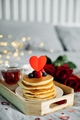 Valentine's day breakfast. Homemade pancakes with berries, cup of tea and red roses. Copy space - PhotoDune Item for Sale