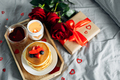 Valentine's day breakfast concept. Pancakes with berries, roses flowers, cup of tea, gift box - PhotoDune Item for Sale