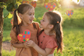 Cute loving sisters hold heart with puzzles supporting each other on autism Day - PhotoDune Item for Sale