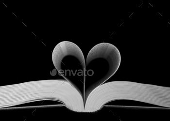 Closeup shot of heart-shaped book pages on a black background