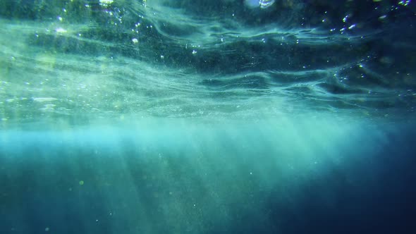 Underwater view of ocean's turquoise surface.