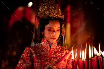 Chinese woman make wishes, pray, and light candles.