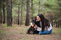 Young caucasian woman hugging her mixed breed dog at a pine forest. - PhotoDune Item for Sale