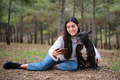 Young caucasian woman taking a selfie hugging her mixed breed dog at a forest. - PhotoDune Item for Sale