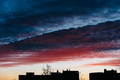 Silhouettes of buildings in the skyline of a city with dramatic reddish clouds at dusk - PhotoDune Item for Sale
