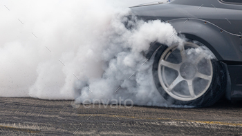 Car wheel spinning wheel and smoking, Race car doing lot of smoke on race track, Car wheel drifting.