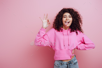 owing okay gesture on pink background