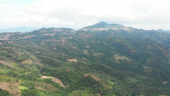 Unique aerial view of tea plantation on hill and tea pickers village on ridge 