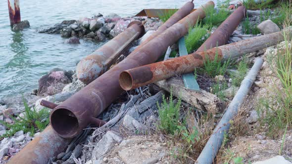 Metal Pipes on the Ground Near a River