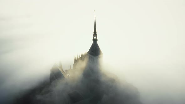 Aerial Shot, Fog Clouds Flowing Over Famous Majestic Mont Saint Michel Fortress Castle During Epic