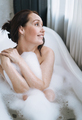 Self loving adult smiling woman with brunette hair taking bath with foam at home - PhotoDune Item for Sale