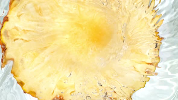 Super Slow Motion Shot of Pineapple Slice Falling Into Water Whirl at 1000 Fps