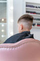 The hairdresser makes a boy's haircut with scissors and a comb - PhotoDune Item for Sale