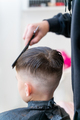 The hairdresser makes a boy's haircut with a clipper - PhotoDune Item for Sale