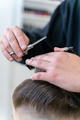 The hairdresser makes a boy's haircut with a clipper - PhotoDune Item for Sale