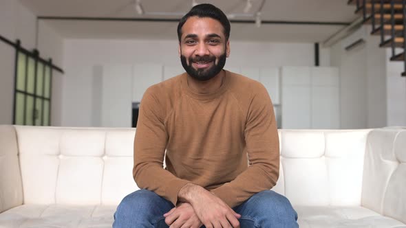 Smiling Friendly Young Bearded Indian Freelancer Guy Look and Talks at Camera