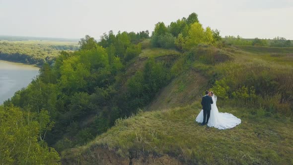 Couple Kisses on Steep Riverbank Near Field Upper View