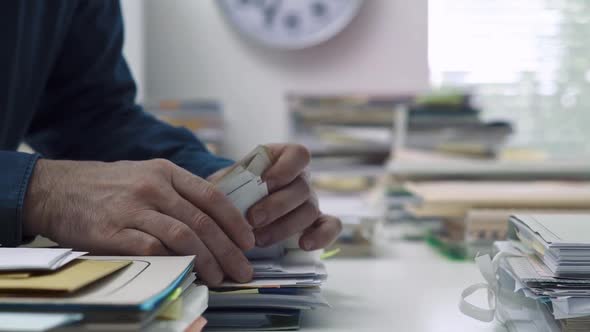 Employee working in the office and piles of paperwork