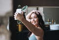 Self loving middle aged woman in underwear taking selfie with mobile phone in bathroom at home - PhotoDune Item for Sale