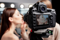 selective focus of digital camera with makeup artist applying lip gloss on beautiful model - PhotoDune Item for Sale