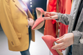 cropped view of stylist holding shoes near model in blazer - PhotoDune Item for Sale