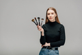 attractive makeup artist holding makeup brush set isolated on grey - PhotoDune Item for Sale
