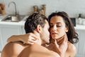 Passionate woman and man with closed eyes hugging in kitchen - PhotoDune Item for Sale