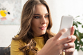 Selective focus of smiling depended woman using smartphone on couch - PhotoDune Item for Sale