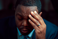 Black or African American business man sitting down looking anxious and depressed - PhotoDune Item for Sale