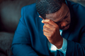 Black or African American business man sitting down looking anxious and depressed - PhotoDune Item for Sale