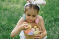 Girl with eggs basket and bunny ears on Easter egg hunt in garden. - PhotoDune Item for Sale