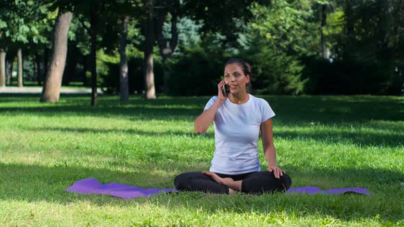 Girl Doing Yoga in the Park and Talking on Cellphone