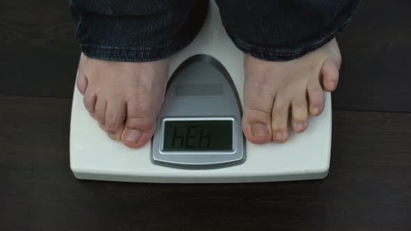 Overweight Male Feet on Weighing Scales, Measuring Kilograms After Workout